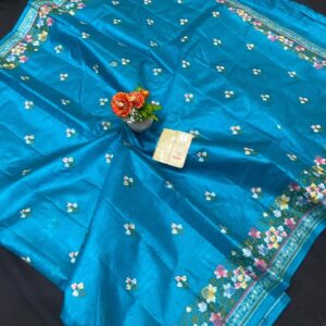 A vibrant feroza turquoise blue pure Bhagalpuri Munga silk handloom saree from Bhavya Lakshmi Fabrics featuring detailed multicolored floral embroidery scattered butis and an ornate floral border.