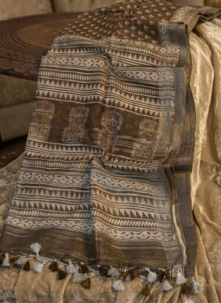 Elegant earth brown semi-linen Bhagalpuri saree featuring white block prints, architectural pallu details, and pompom tassels.