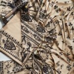 An unstitched cream Katan silk suit material set by Bhavya Lakshmi Fabrics featuring extensive black monochrome Madhubani prints of elephants, peacocks, and fish with geometric borders.