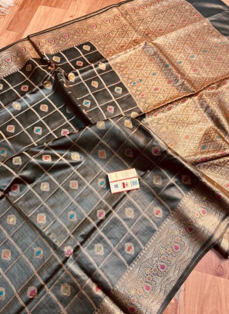 Sophisticated midnight black pure Bhagalpuri Munga silk saree from Bhavya Lakshmi Fabrics featuring gold zari checks with multi-color floral Meenakari butis and an intricate gold zari border