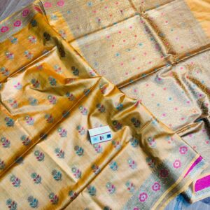 Golden yellow pure Bhagalpuri Munga silk saree featuring small multi-color floral butis, an intricate gold zari border with pink accents, and a heavily woven zari pallu, spread on a floor.