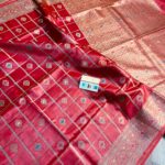 Vibrant crimson red pure Bhagalpuri Munga silk saree from Bhavya Lakshmi Fabrics featuring gold zari checks with multi-color floral Meenakari butis and an intricate gold zari border