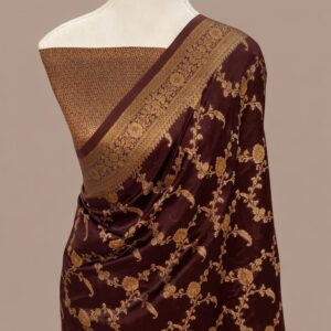 Dark wine Banarasi silk saree with an all-over intricate gold zari floral jaal pattern and a broad traditional zari border, draped on a mannequin