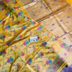 Vibrant golden yellow pure Bhagalpuri Munga silk saree from Bhavya Lakshmi Fabrics featuring a multi-color floral Meenakari jaal and an intricate gold zari border