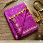 A vibrant magenta pink Kota silk saree from Bhavya Lakshmi Fabrics featuring gold embroidered star butis, a temple zari border, and yellow pompom tassels.