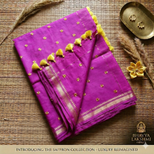 A vibrant magenta pink Kota silk saree from Bhavya Lakshmi Fabrics featuring gold embroidered star butis, a temple zari border, and yellow pompom tassels.