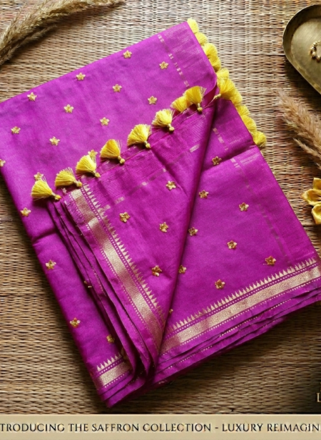 A vibrant magenta pink Kota silk saree from Bhavya Lakshmi Fabrics featuring gold embroidered star butis, a temple zari border, and yellow pompom tassels.
