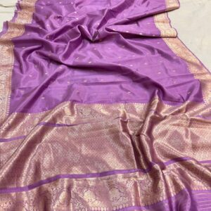A close-up view of a sheer Lavender Organza Banarasi Saree from Bhavya Lakshmi Fabrics featuring delicate golden zari butis and a grand metallic zari border.
