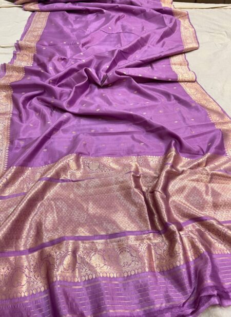 A close-up view of a sheer Lavender Organza Banarasi Saree from Bhavya Lakshmi Fabrics featuring delicate golden zari butis and a grand metallic zari border.