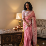 Dusty rose pink linen blend Bhagalpuri saree featuring white geometric Bagru prints and elegant pompom tassels.