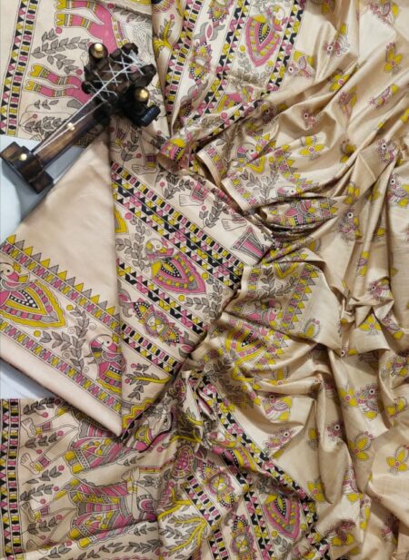 A premium unstitched beige Katan silk suit material set by Bhavya Lakshmi Fabrics featuring detailed multicolored Madhubani art hand-painted style prints on the top, bottom, and dupatta.