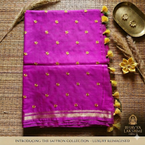 A vibrant magenta pink Kota silk saree from Bhavya Lakshmi Fabrics featuring gold embroidered star butis, a temple zari border, and yellow pompom tassels.