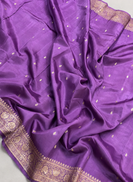 A full-length view of a luxurious Mauve Purple Organza Banarasi Saree from Bhavya Lakshmi Fabrics displaying delicate golden zari butis and a grandly detailed floral zari pallu.
