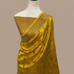 Mustard yellow Banarasi Katan silk saree with an all-over gold zari floral jaal pattern and a decorative zari border