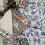 Off-white dupion slub silk unstitched suit material featuring traditional green, orange, and blue Madhubani fish prints.