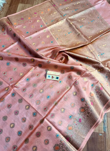 Elegant pastel peach pure Bhagalpuri Muga silk saree from Bhavya Lakshmi Fabrics featuring multi-color floral butis and an intricate gold zari border