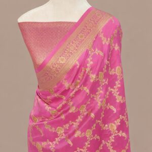 Rani pink Banarasi Katan silk saree with an all-over gold zari floral jaal pattern and a decorative zari border, draped on a mannequin