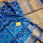 Vibrant royal blue pure Bhagalpuri Munga silk saree from Bhavya Lakshmi Fabrics featuring gold zari checks with multi-color floral Meenakari butis and an intricate gold zari border