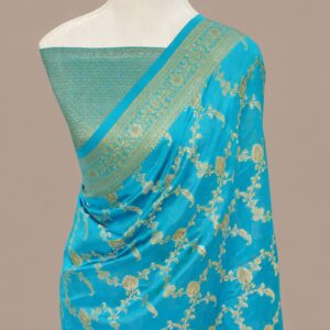 Turquoise blue Banarasi Katan silk saree with an all-over gold zari floral jaal pattern and a decorative zari border, draped on a mannequin