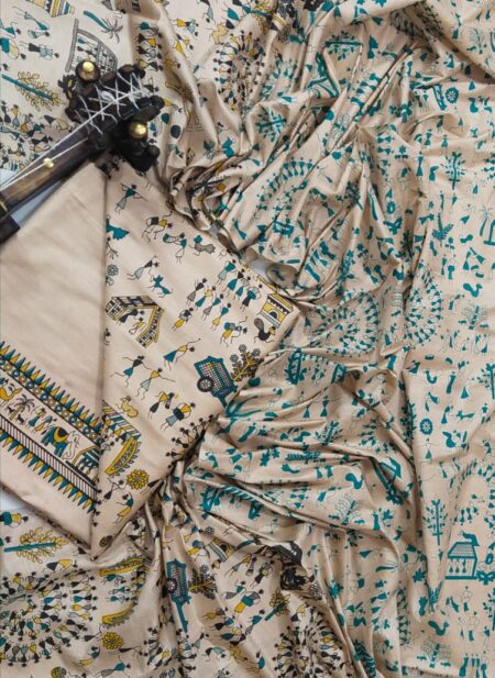 An unstitched beige Katan silk suit material set by Bhavya Lakshmi Fabrics featuring detailed teal blue and mustard yellow Warli tribal dance prints, geometric borders, and a matching dupatta