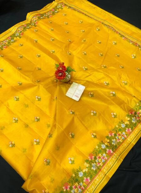 A vibrant yellow pure Bhagalpuri Munga silk handloom saree from Bhavya Lakshmi Fabrics featuring detailed multicolored floral embroidery scattered butis and an ornate floral border.