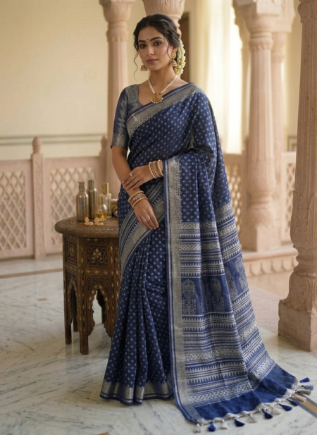 Elegant indigo blue semi-linen Bhagalpuri saree featuring white block prints, architectural pallu details, and pompom tassels.