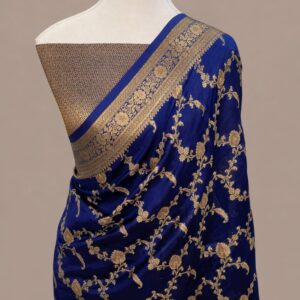 Royal blue Banarasi Katan silk saree featuring an all-over gold zari floral jaal pattern and a decorative zari border, draped on a mannequin.