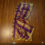 Royal purple and metallic gold zari striped tissue silk saree featuring intricate borders and matching tassel details.
