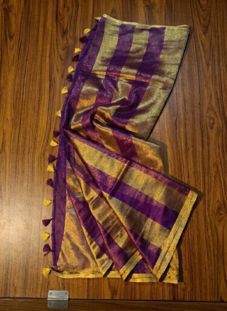 Royal purple and metallic gold zari striped tissue silk saree featuring intricate borders and matching tassel details.