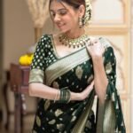Elegant bottle green semi organza saree featuring woven golden zari floral buttas and a matching patterned blouse.