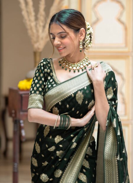 Elegant bottle green semi organza saree featuring woven golden zari floral buttas and a matching patterned blouse.