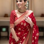 Vibrant bridal red semi organza saree featuring woven golden zari floral buttas and a matching patterned blouse.