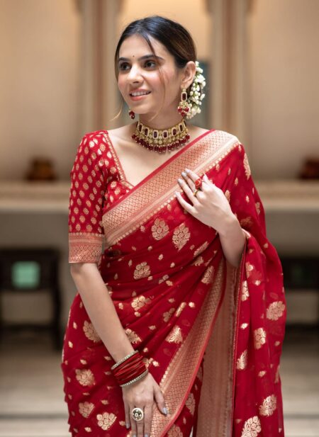 Vibrant bridal red semi organza saree featuring woven golden zari floral buttas and a matching patterned blouse.