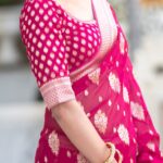 Vibrant rani pink semi organza saree featuring woven golden zari floral buttas and a matching patterned blouse.
