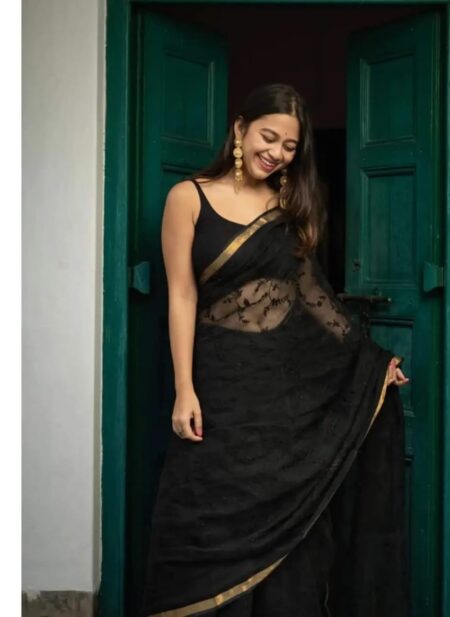 Bhavyaloom jet black bhagalpuri kota doria embroidery saree with thin gold zari border on model in front of green door