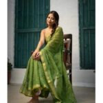 Bhavyaloom moss green bhagalpuri kota doria embroidery saree with gold border draped on model sitting on chair